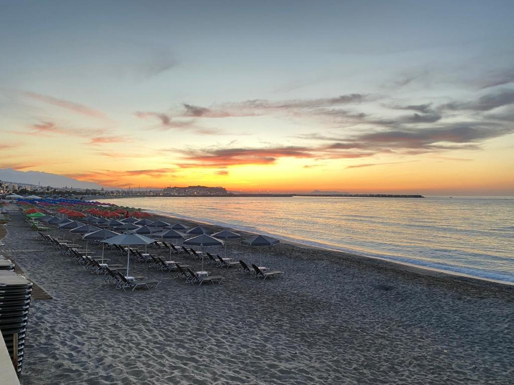Saule riet krastā, kafejnīcas un lietussargi pludmalē, mierīga jūra un skaista ainava.