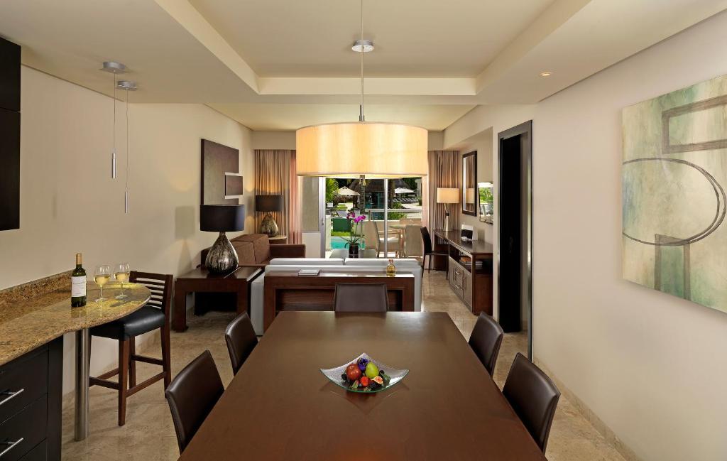 Mūsdienīga viesnīcas numura ēdamzona ar skatu uz dārzu - Paradisus Playa del Carmen.