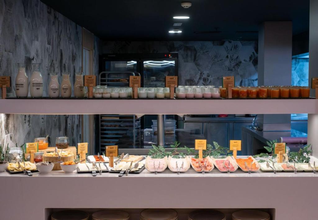 Svaigu ēdienu bufete ar dažādām piena produktiem, siera šķēlēm un saldām uzkodām, kas pasniegtas uz eleganta galda. Ideāla vieta brokastīm vai brīvdienu izbaudīšanai.