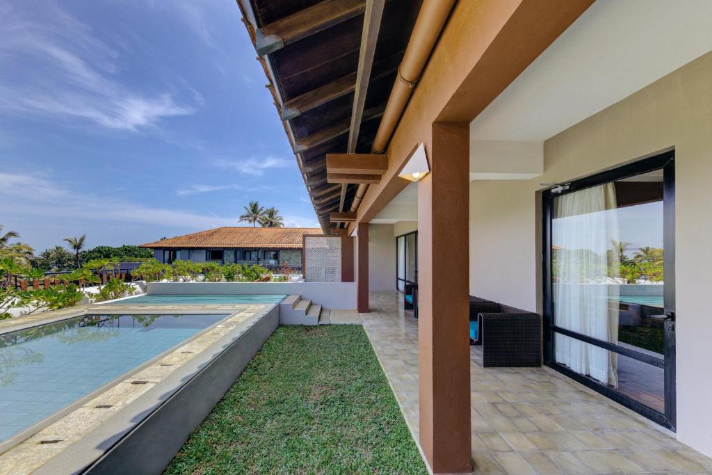 Cinnamon Bey terase ar skatu uz baseinu un dārzu.