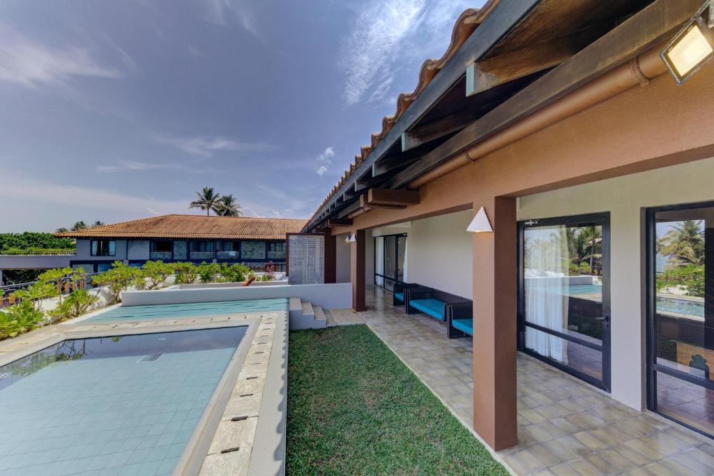 Cinnamon Bey viesnīcas piekrastes terase ar baseinu un dārzu.