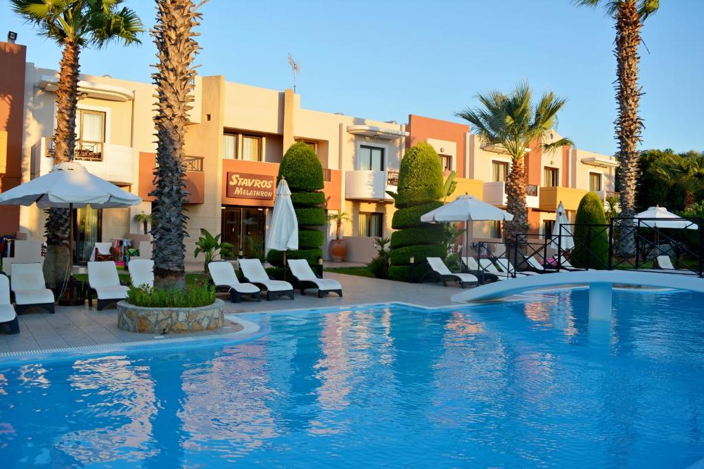 Baseins ar saulessargiem un atpūtas krēsliem, apzaļumota teritorija un viesnīcas fasāde. Ideāla vieta atpūtai un relaksācijai.