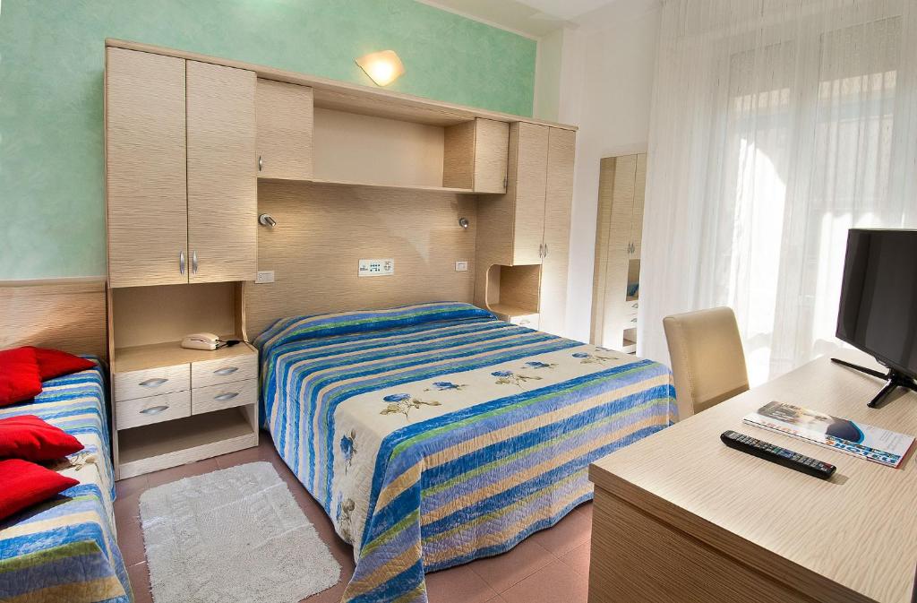 Mūsdienīgs viesnīcas numurs ar diviem gultām, televizoru un rakstāmgaldu, dekorēts ar zilu un dzeltenu gultas veļu. Logi ir ar vieglām aizkariem, radot gaišu un mājīgu atmosfēru.