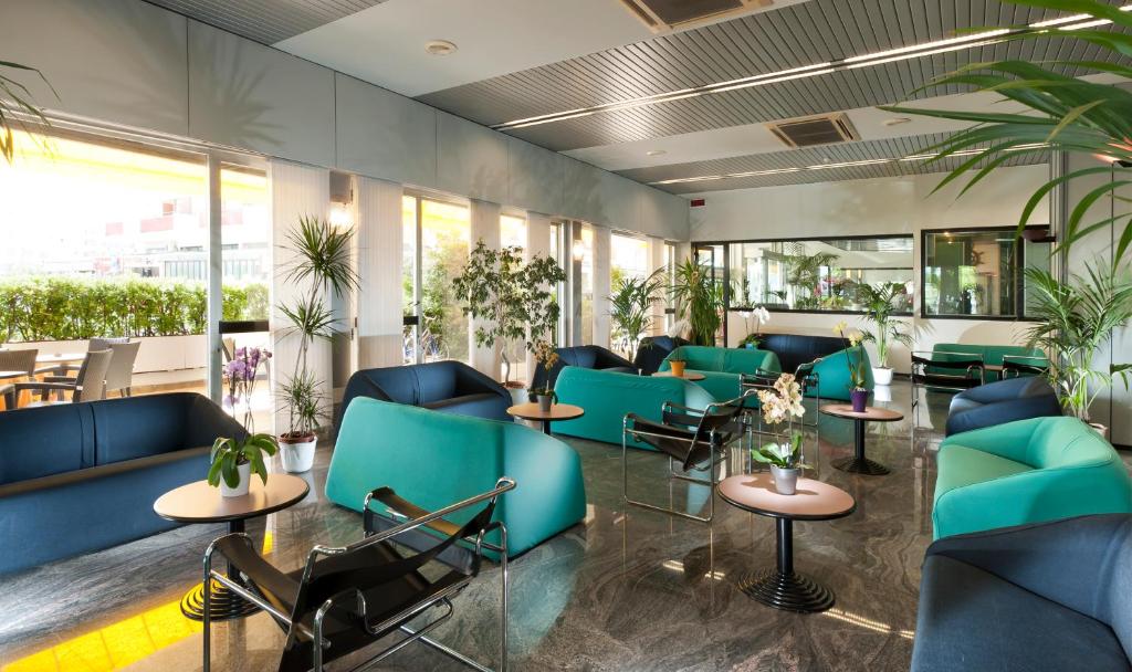 Mūsdienīgs un stilīgs atpūtas telpa ar zaļiem augiem un komfortablu mēbelēšanu, kas rada relaksējošu atmosfēru. Telpā ir daudz gaismas un moderns dizains.