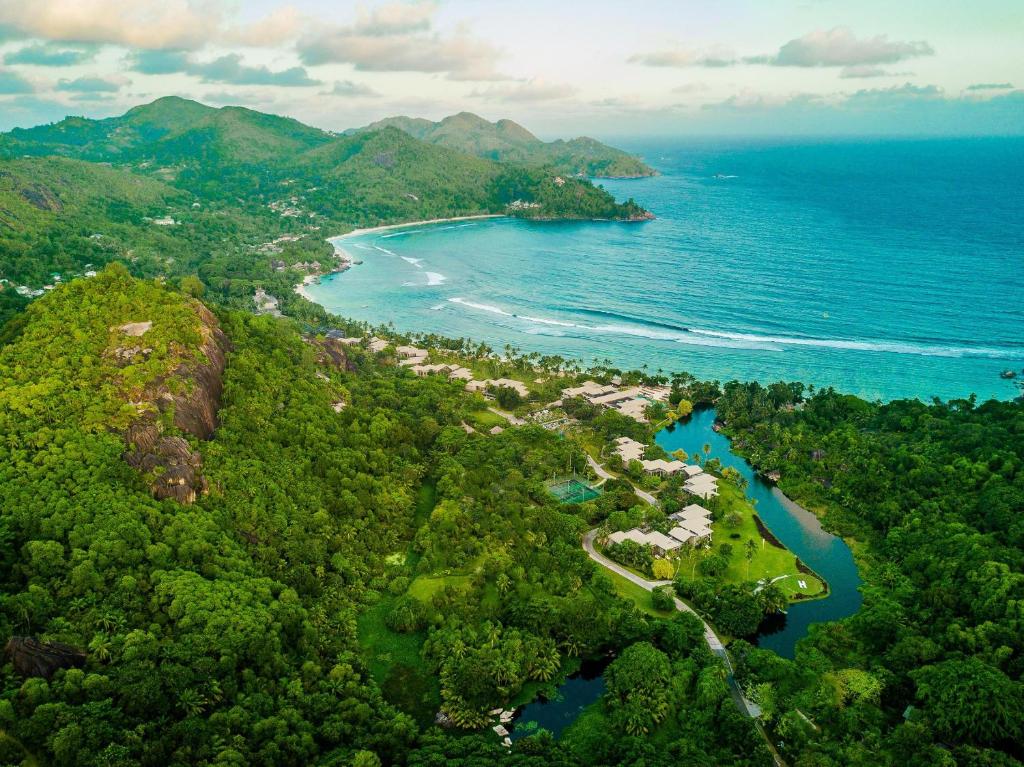 Kempinski Seychelles Resort piekrastē starp zaļiem kalniem un tirkīzzilo okeānu