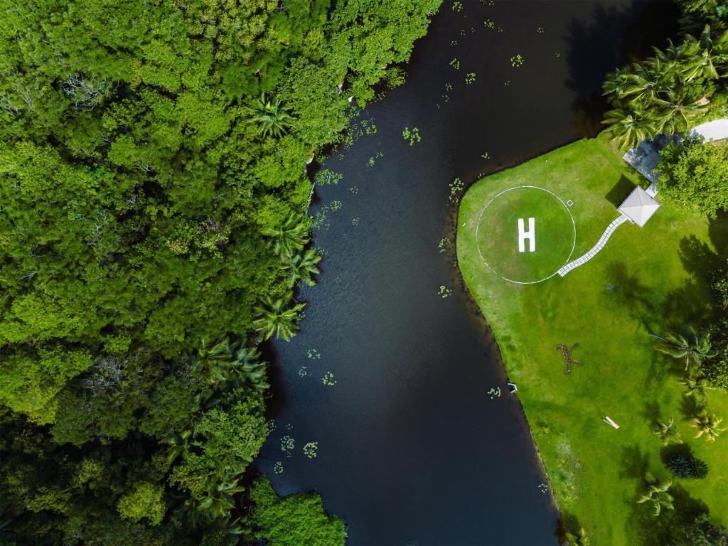 Kempinski Seychelles Resort helikoptera nosēšanās laukums tropu meža un ūdens ielokā.