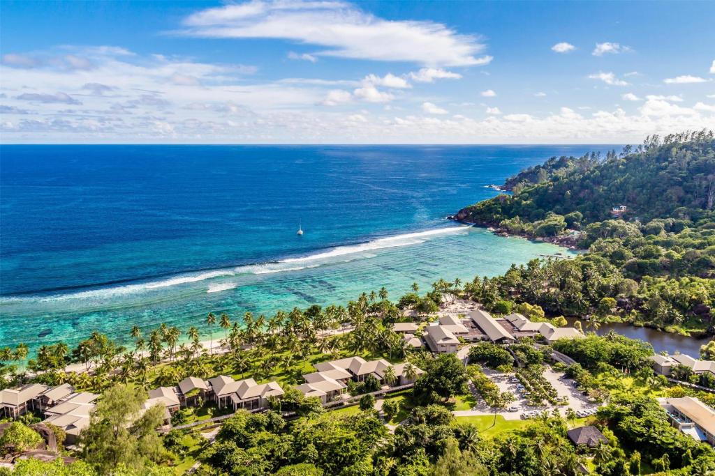 Kempinski Seychelles Resort tropiskā oāze piekrastē ar tirkīzzilu okeānu.