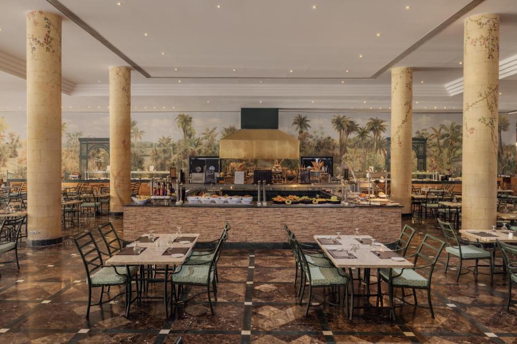 Elegants restorāns ar plašu interjeru, dekorēts ar palmām un ar modernu bufeti, piedāvā ērtas ēdināšanas vietas. Gaisma un dizains rada patīkamu atmosfēru.