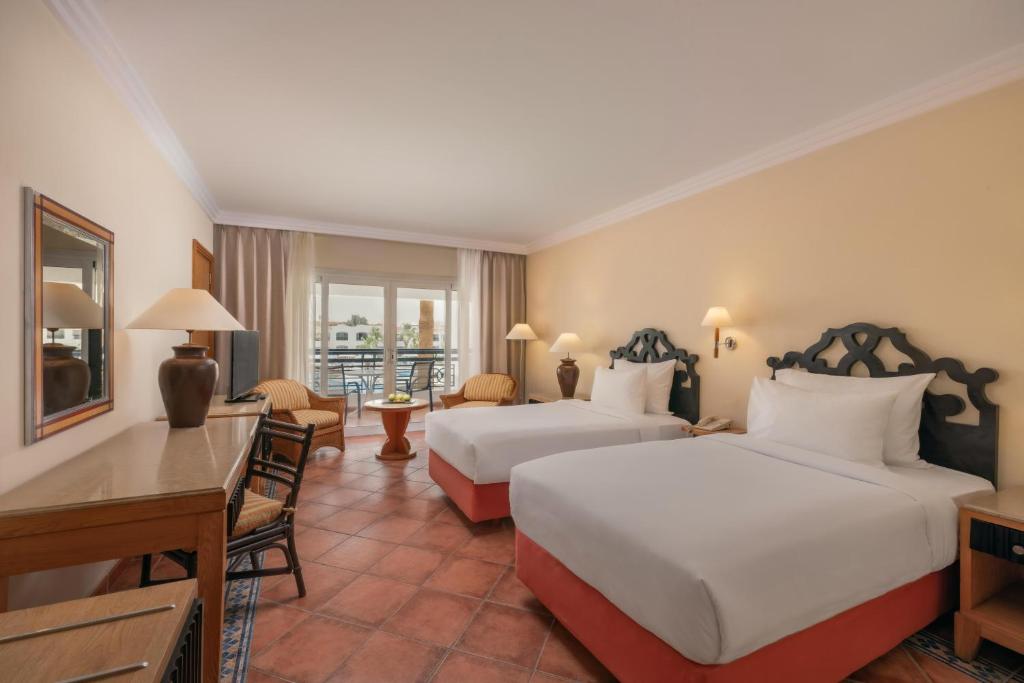 Mūsdienīgs viesnīcas numurs ar divām gultām, koka mēbelēm un balkonu, kas atveras uz skaistu skatu. Gaismas un krāsas rada komfortablu atmosfēru.