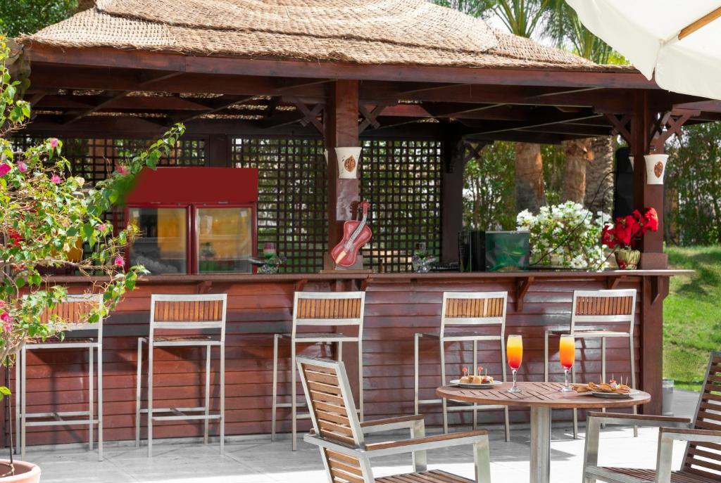 Bārs pie baseina Xperience Kiroseiz Parkland ar dzērieniem un uzkodām.