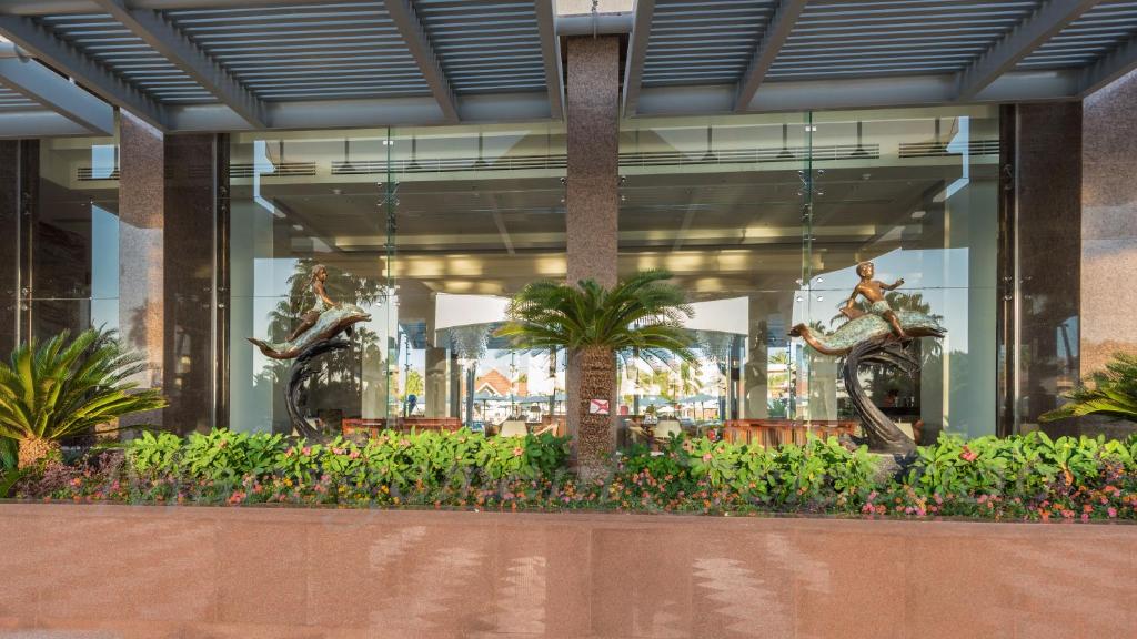 Xperience Kiroseiz Parkland stilīga ieeja ar skulptūrām un zaļumiem