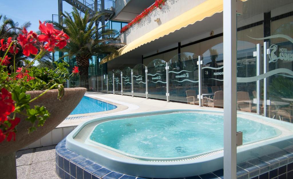 Baseins ar burbuļvannu viesnīcas teritorijā, apkārt skaisti ziedoši augi un palmām. Ideāla atpūtas vieta saulainā dienā.