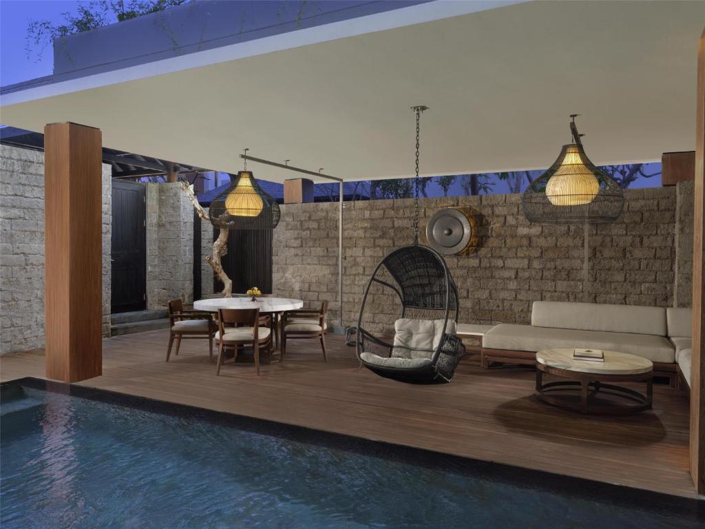 Mūsdienīga atpūtas zona ar peldbaseinu, elegantu mēbelēm un rotājošām lampām, radot relaksējošu atmosfēru. Ideāla vieta atpūtai un socializācijai.