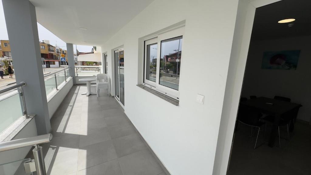 Mūsdienīgs balkons ar skatu uz ielu, aprīkots ar ērtu galdu un krēslu, un gaišām sienām. Ideāla vieta relaksācijai un baudīšanai.