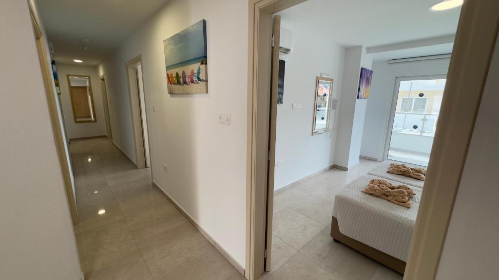 Mūsdienīgs interjers ar gaišām krāsām un plašu koridoru, kas ved uz guļamistabu. Uz sienām ir gleznas, radot patīkamu atmosfēru.