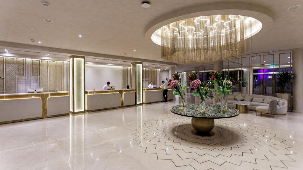 Eleganta recepcija Sunrise Remal Beach Resort ar modernu apgaismojumu un ziedu dekoru.