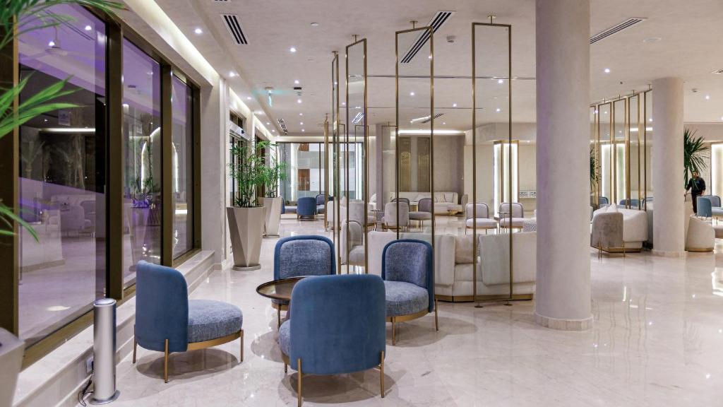 Elegants interjers pie Sunrise Remal Beach Resort, moderni krēsli un plašs apgaismojums.