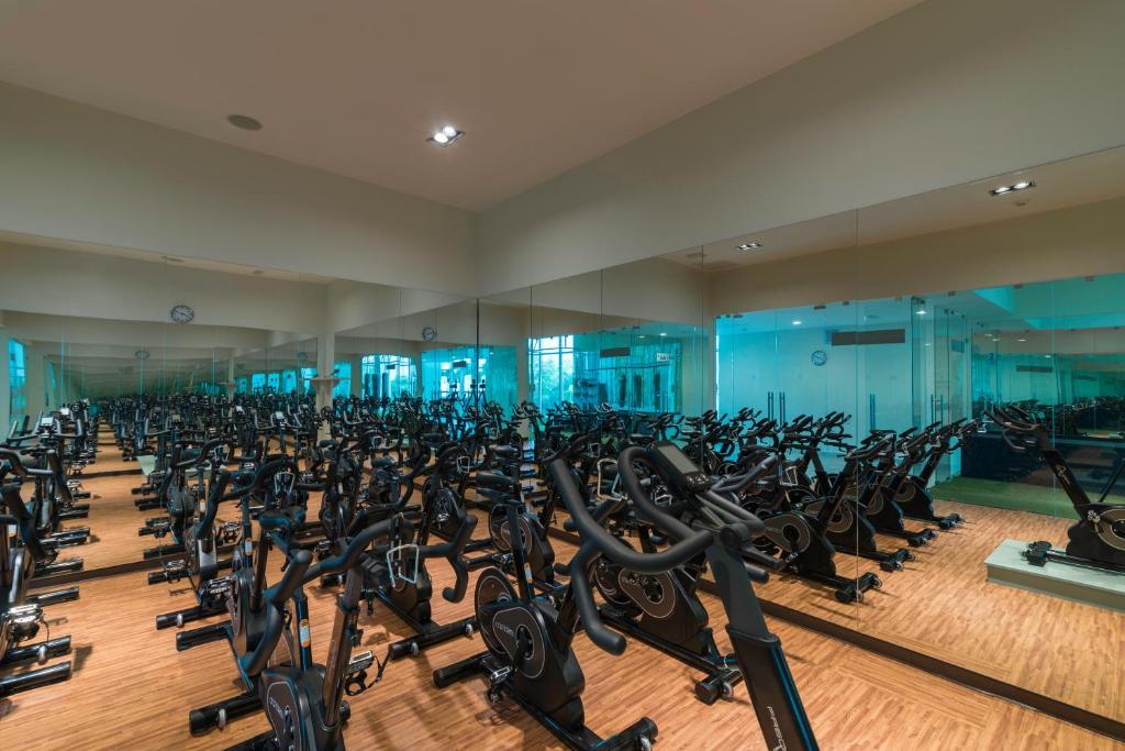 Mūsdienīga sporta zāle ar daudziem velosipēdiem, kas izvietoti rindās, un spoguļiem uz sienām, radot paplašinājuma efektu. Gaismas un koka grīda piešķir siltumu un komfortu.