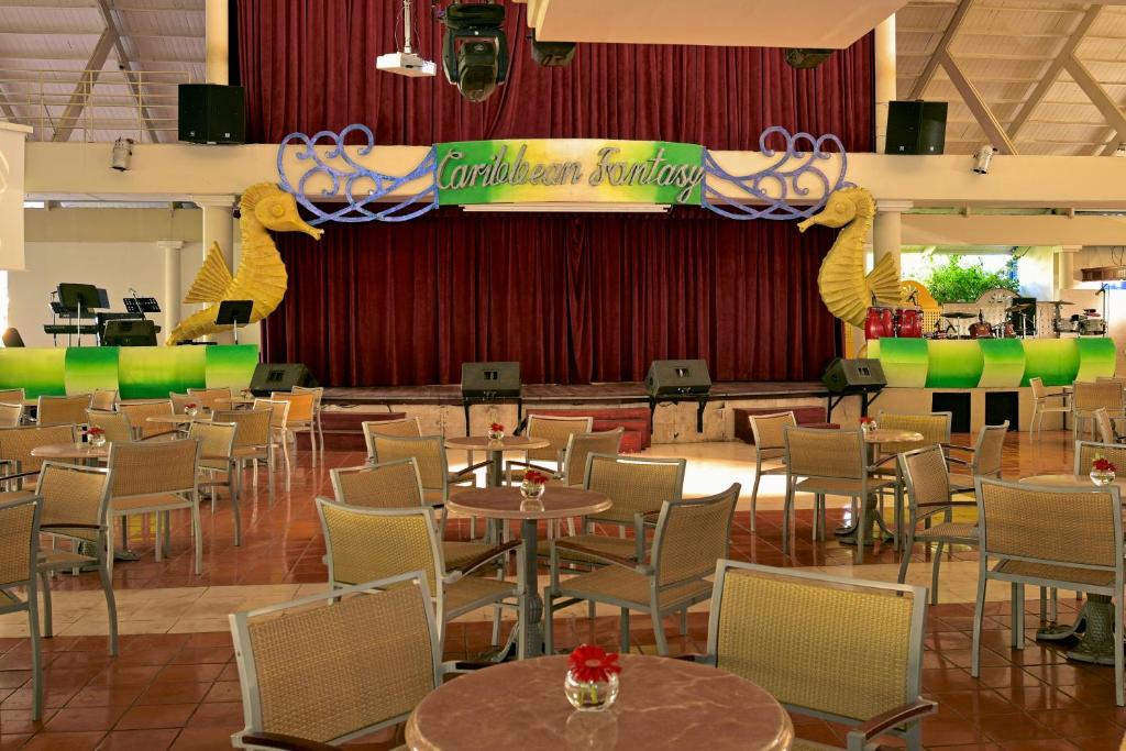 Karību jūras tematikas izklaides vieta ar skatuvi, dekorēta ar jūras zirdziņiem un sarkaniem aizkariem, kurā ir galdi un krēsli. Ideāla vieta mūzikas un izklaides pasākumiem.