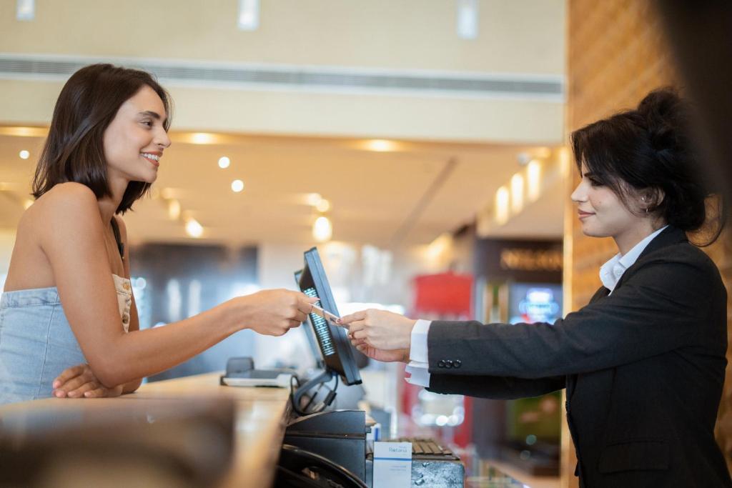 Viesnīcas Media Rotana reģistratūrā klients saņem pakalpojumu.