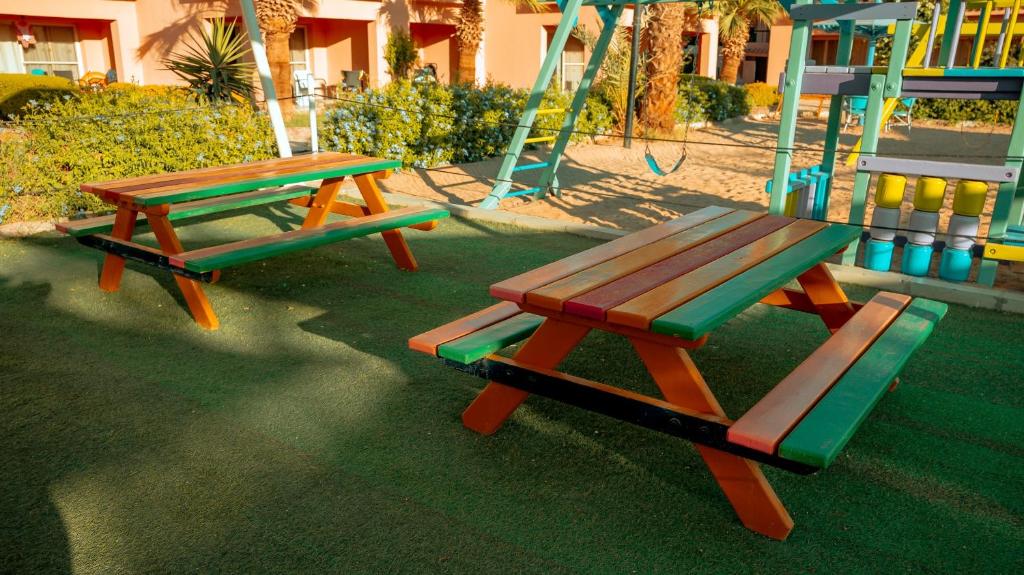 Krāsaini galdi un šūpoles bērnu rotaļu laukumā pie Ali Baba Palace Resort.