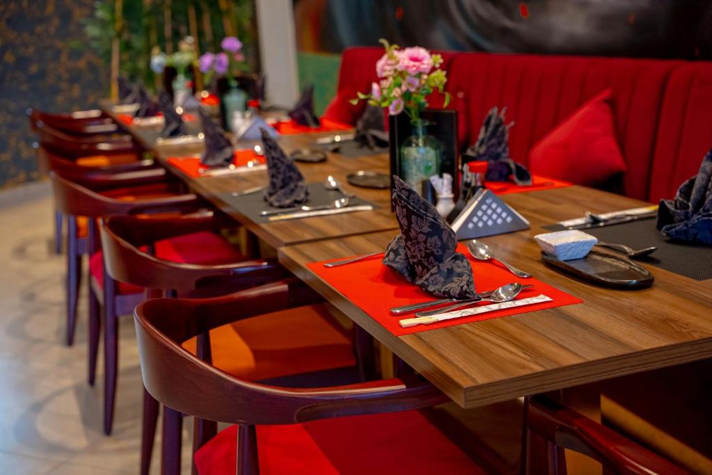 Eleganta galda iestatījums restorānā Ali Baba Palace Resort ar ziediem un dekoratīviem salvetēm.