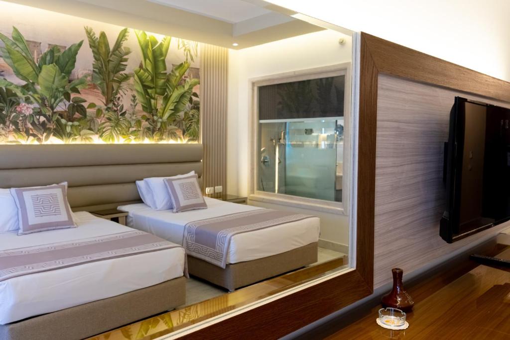 Mūsdienīgs numurs ar divām gultām un zaļām augu sienām Ali Baba Palace Resort.