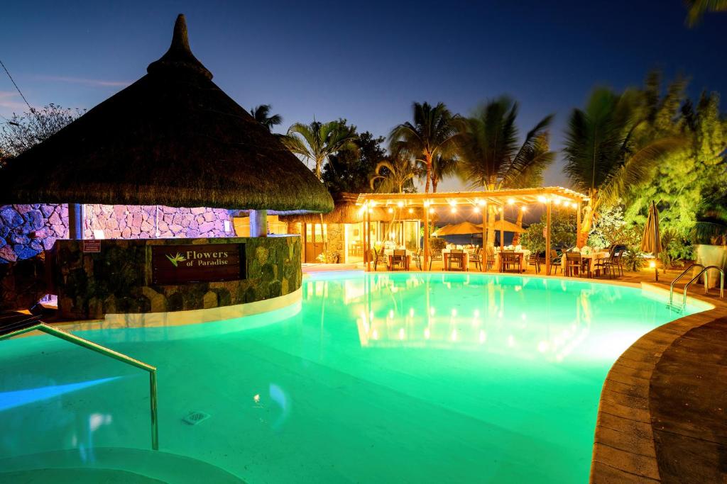 Viesnīca Flowers of Paradise ar apgaismotu baseinu naktī