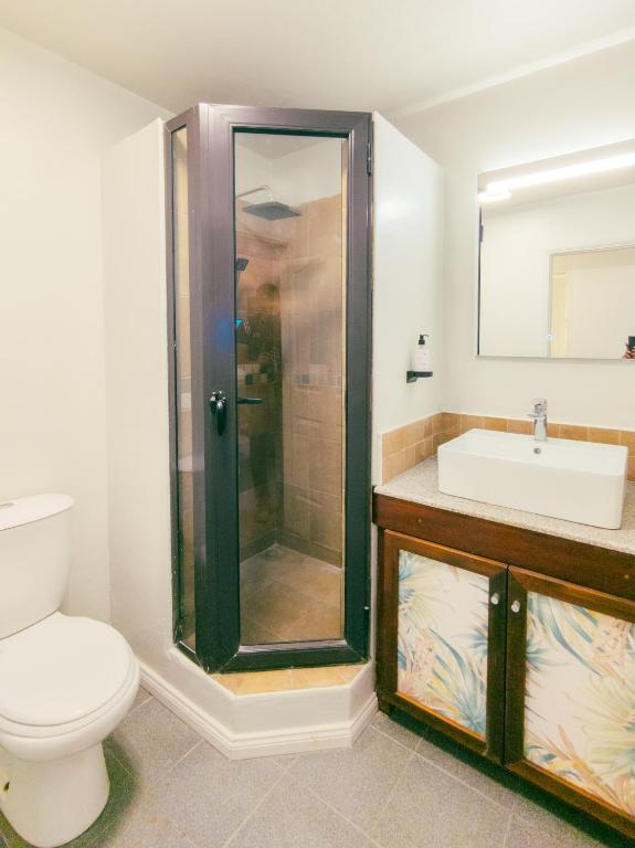 Flowers of Paradise vannas istaba ar dušu un izlietni.