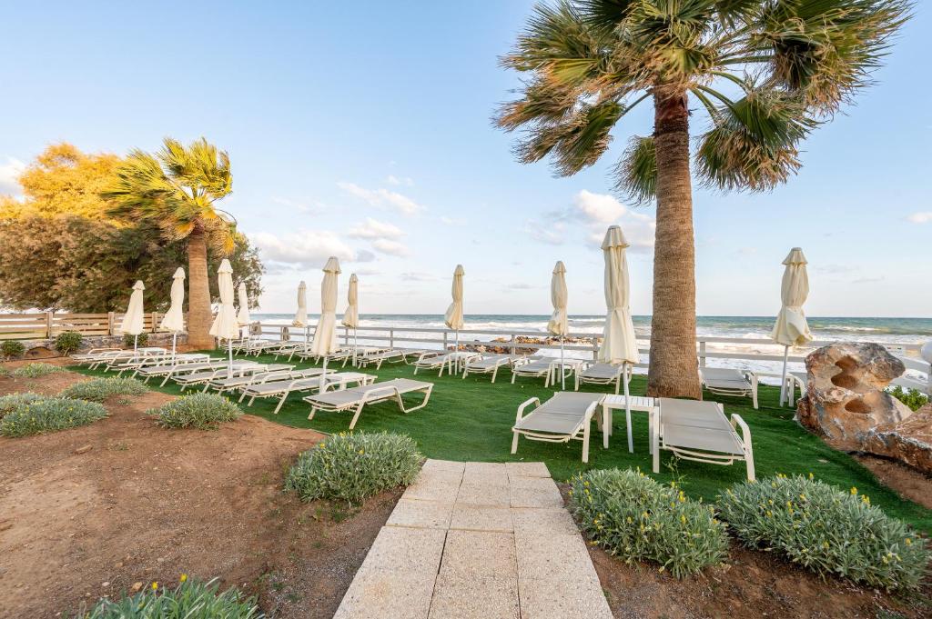 Harmony Rethymno Beach atpūtas zona ar skatu uz jūru un palmām.