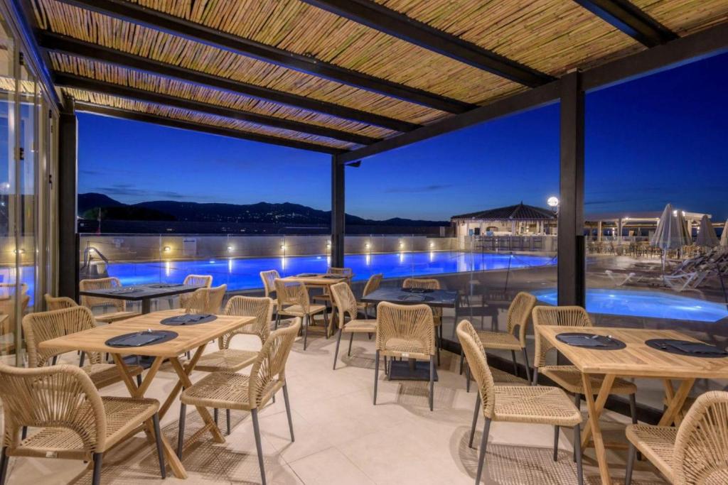 Neptuno Beach Resort terase ar skatu uz baseinu un kalniem naktī.