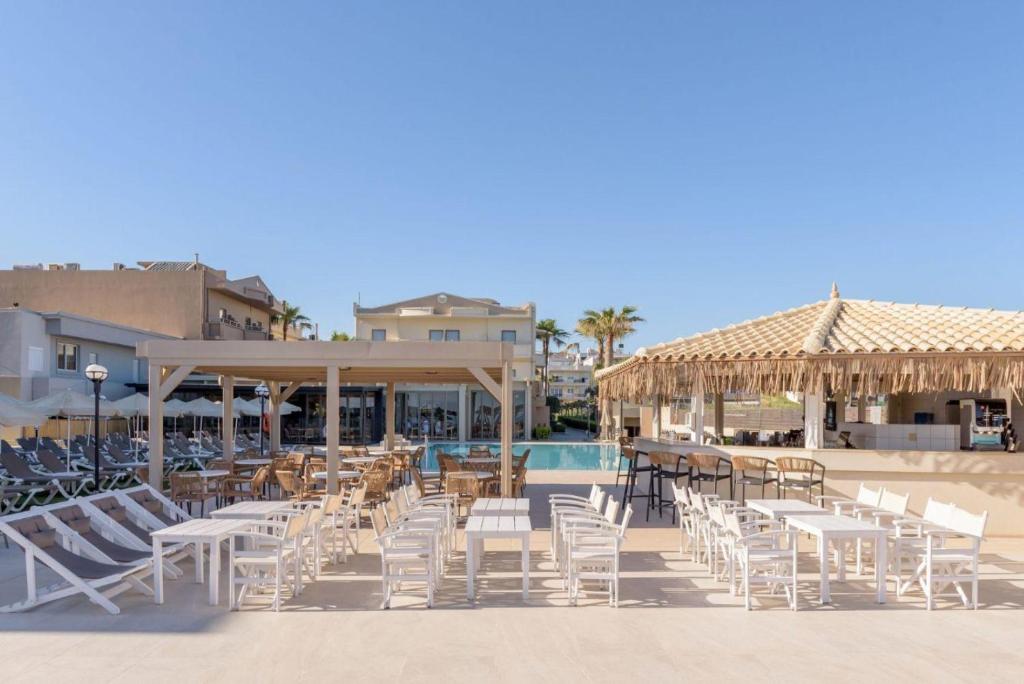 Neptuno Beach Resort baseins ar atpūtas zonu un bāru.