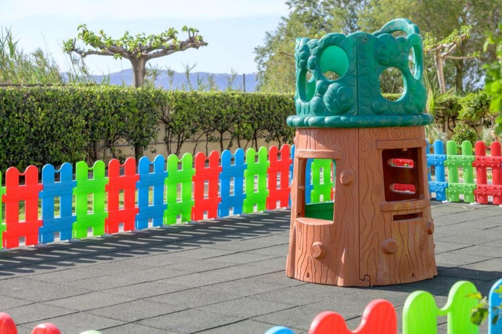 Bērnu rotaļu laukums Neptuno Beach Resort ar krāsainu žogu un rotaļām.