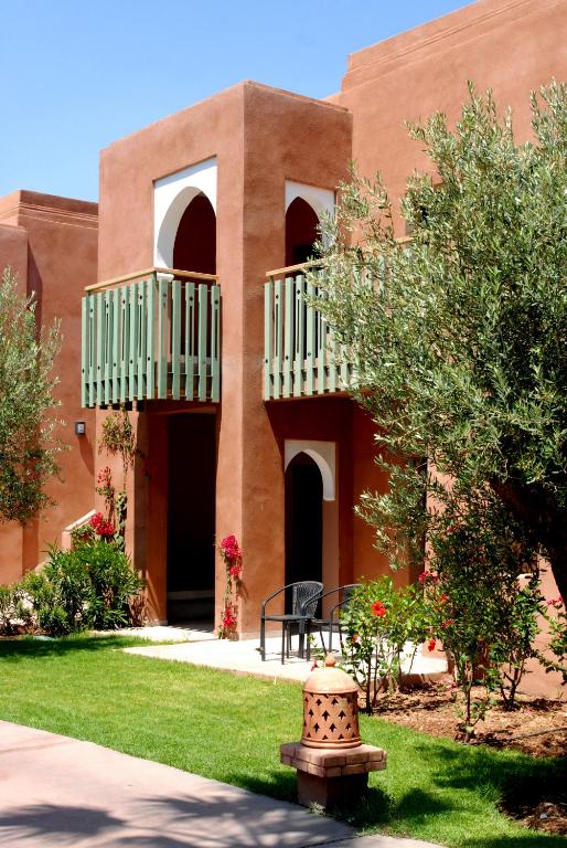 Ārējā ainava ar apbūves kompleksu, kas raksturojas ar sarkanu apdari un zaļām balkona margām, apkārtne rotāta ar augiem un zālienu. Ideāla vieta atpūtai un relaksācijai.