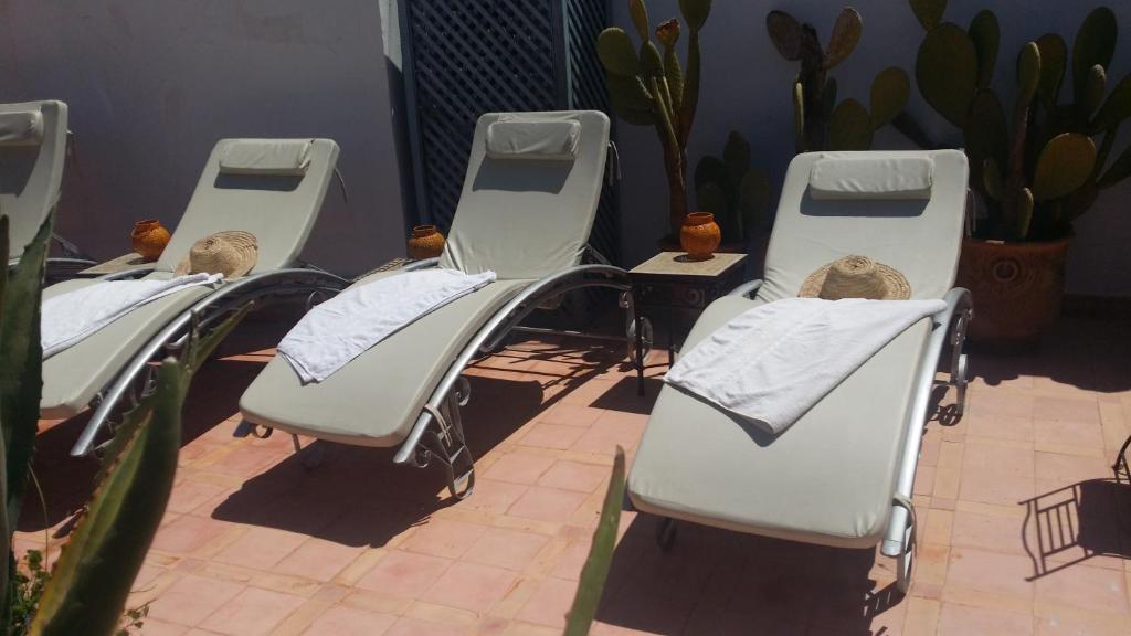 Sauļošanās krēsli ar dvieļiem un cepurēm, izvietoti saulainā iekšpagalmā, ko ieskauj kaktusi. Ideāla vieta atpūtai un relaksācijai.