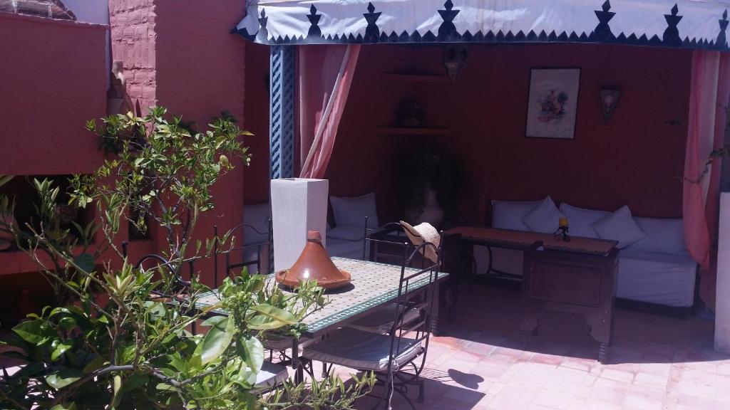 Koptažs ar ērtu āra atpūtas stūri, kurā ir galdiņš, krēsli un dekora elementi, kas rada relaksējošu atmosfēru. Aplokā ir zaļumi un mākslinieciskas detaļas, kas piešķir vietai raksturu.