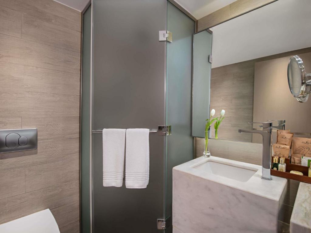 Mūsdienīgs vannas istabas dizains Rixos Premium Tekirova, ar stikla dušu.