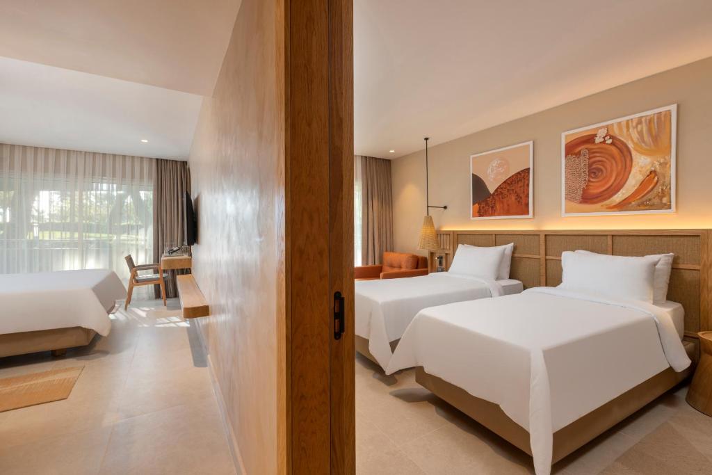 Moderns numurs Rixos Premium Tekirova ar divām gultām un balkonu.