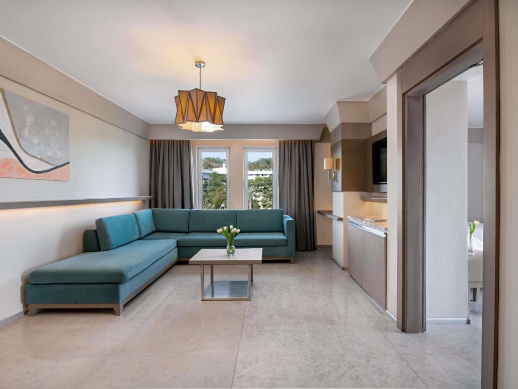 Mūsdienīgs viesnīcas numurs Rixos Premium Tekirova ar dzīvojamo zonu.