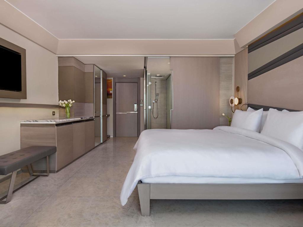 Moderns numurs Rixos Premium Tekirova ar elegantu interjeru un televizoru.