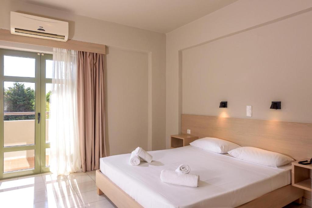 Gaišs un mūsdienīgs numurs viesnīcā Zeus Hotels Ydoria Resort ar balkonu.