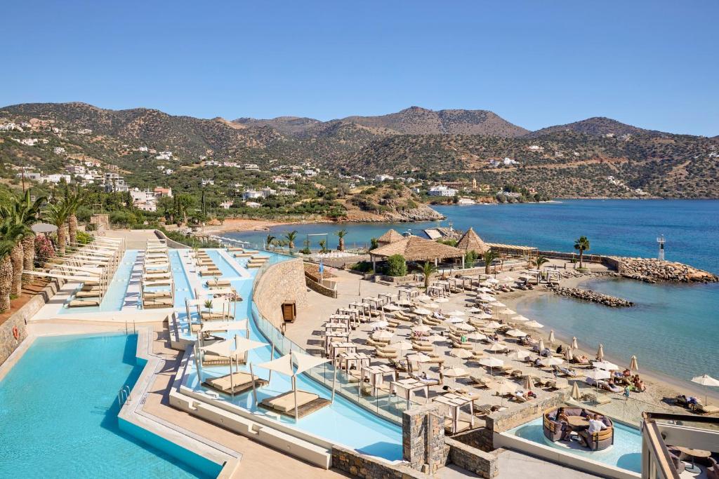 Skats uz Mirabello Bay Luxury Resort peldbaseiniem un pludmali piekrastē.