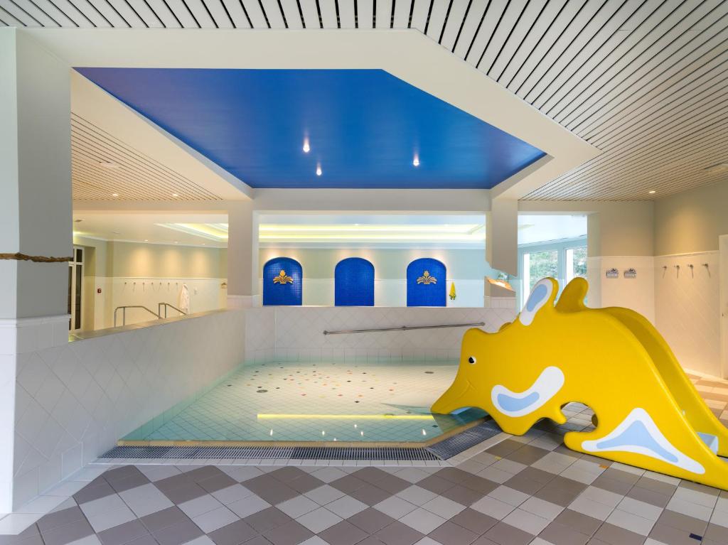 Vannas prieku zona ar dzeltenu, jūras zirdziņa formas slīdkalniņu un mierīgu ūdeni. Gaismas un krāsu kombinācija rada relaksējošu atmosfēru.