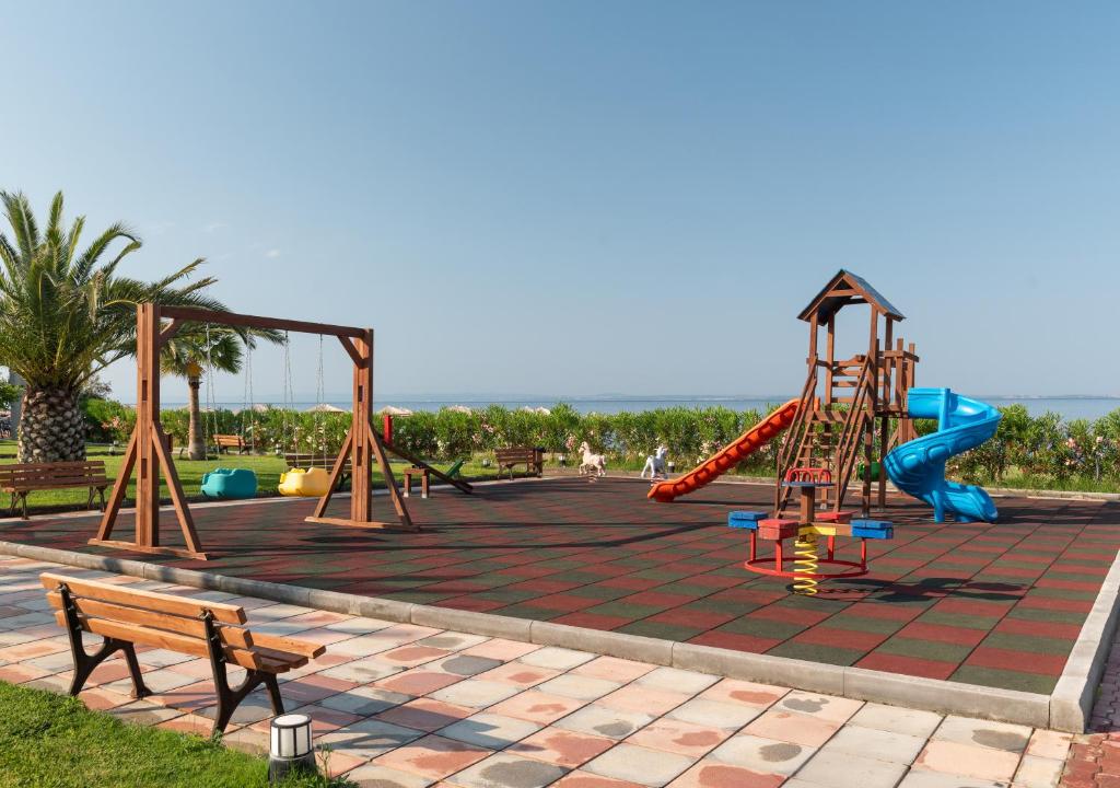 Bērnu rotaļu laukums Sea Coast Resort Halkidiki piekrastē ar šūpolēm un slidkalniņu.