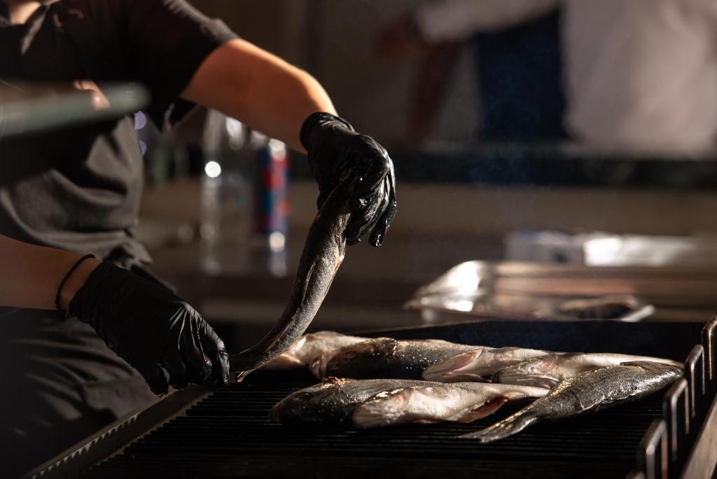 Grilēšanas process pie Sea Coast Resort Halkidiki ar svaigiem zivīm