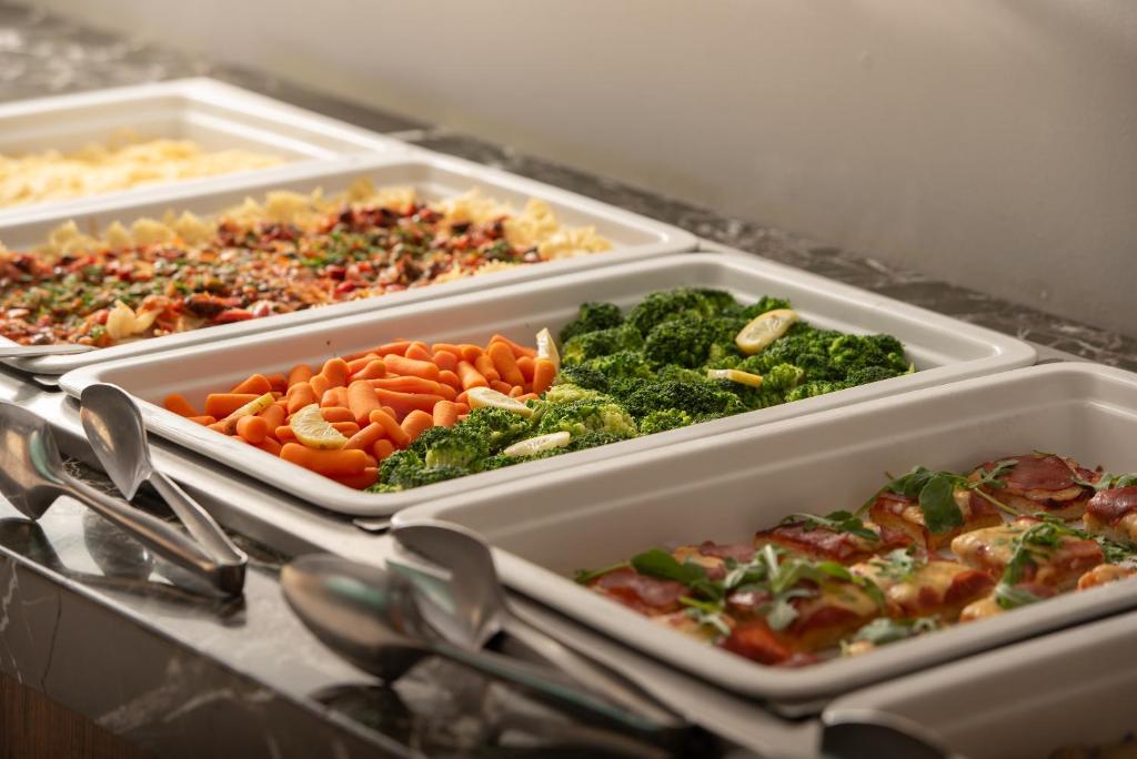 Gards ēdiens pie Sea Coast Resort Halkidiki bufetes ar dārzeņiem un pastu.