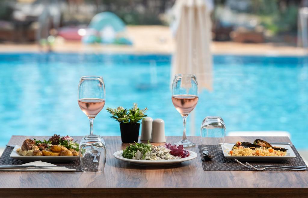 Gards ēdiens un rozā vīns pie Sea Coast Resort Halkidiki baseina.