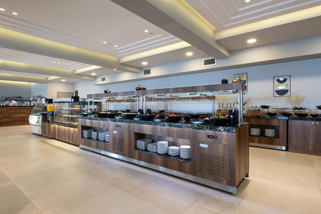 Pusdienu zāle pie Sea Coast Resort Halkidiki ar bufetes stilu un dažādiem ēdieniem.