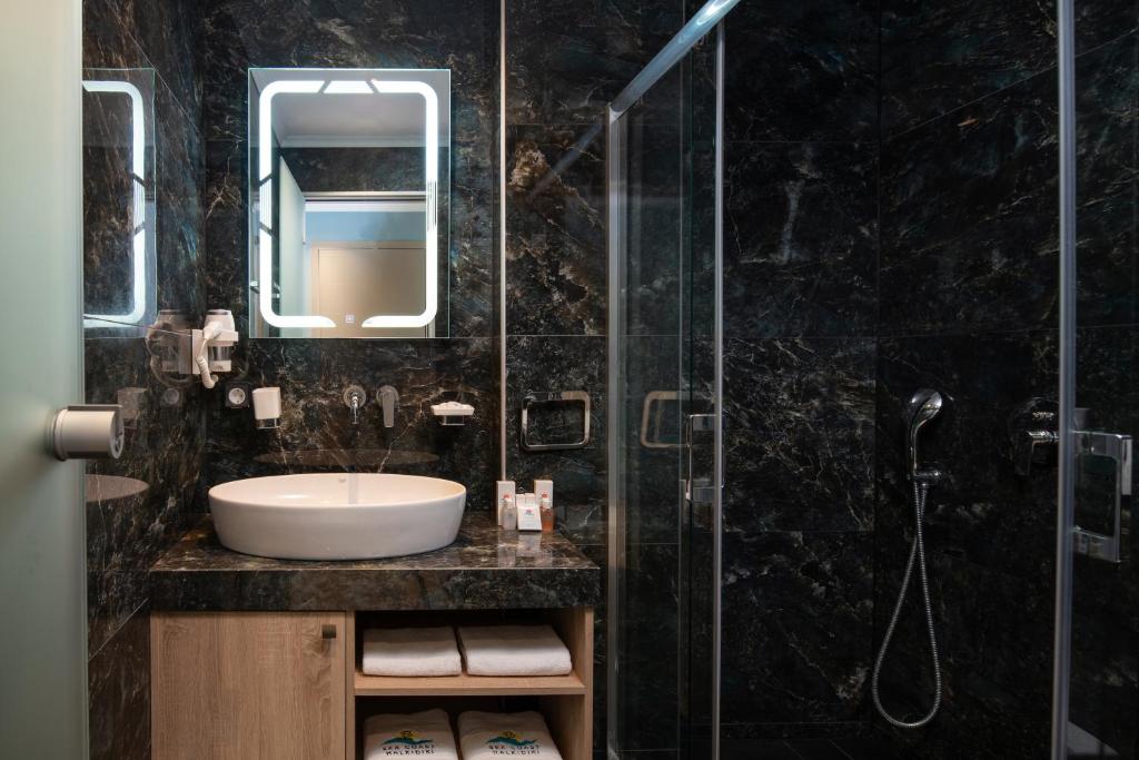 Mūsdienīga vannas istaba ar melnu akmens apdari pie Sea Coast Resort Halkidiki