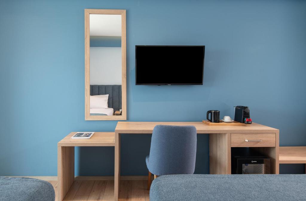 Mūsdienīgs numurs Sea Coast Resort Halkidiki ar televizoru un rakstāmgaldu.